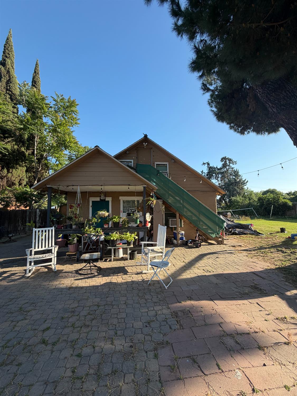 924 Cheatham Court Modesto, CA 95351 - Photo 2 of 5 a backyard of a house with table and chairs under an umbrella