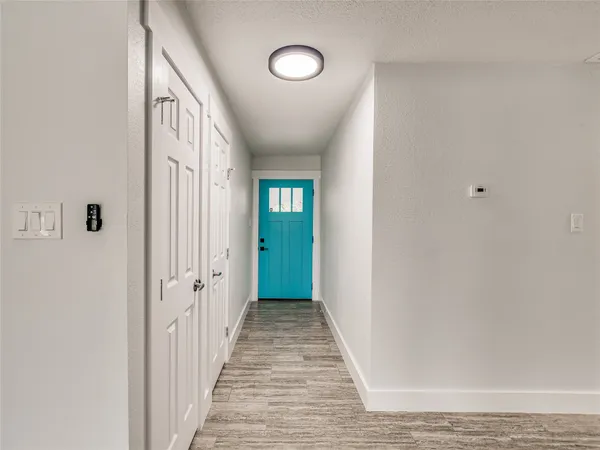 a view of a hallway with wooden floor and closet