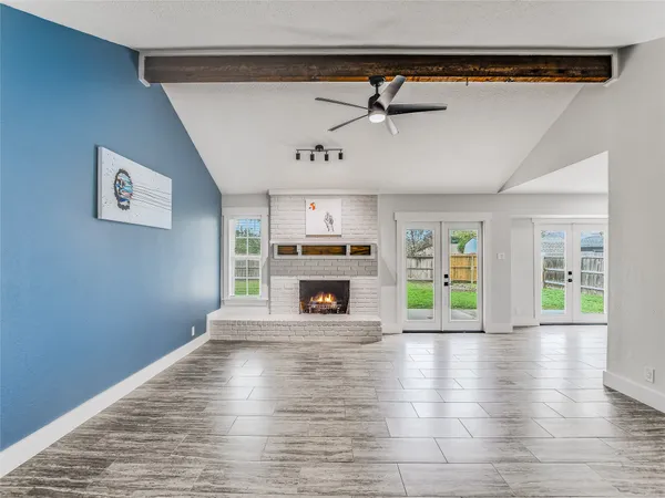 a view of an empty room with window and fire place