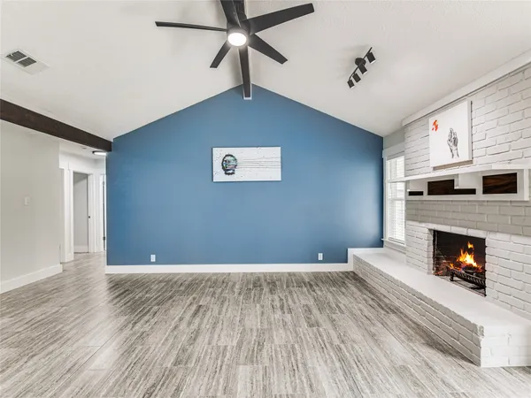 a view of empty room with wooden floor and fireplace
