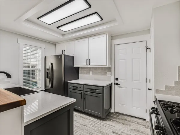 a kitchen with a stove a refrigerator and a cabinets
