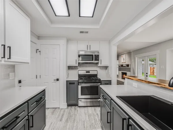 a kitchen with stainless steel appliances a stove sink and cabinets
