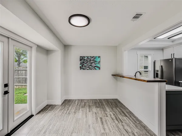 a view of a hallway with wooden floor and a window