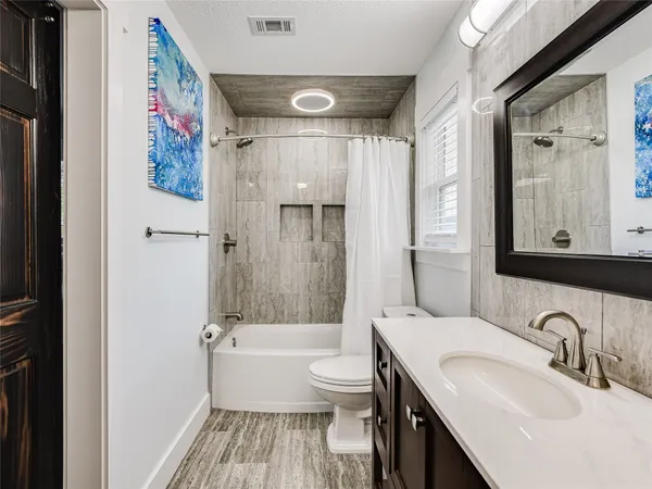 a bathroom with a sink a toilet and a large mirror