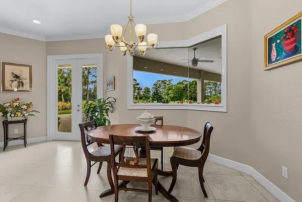 a dining room with furniture a large window and a chandelier