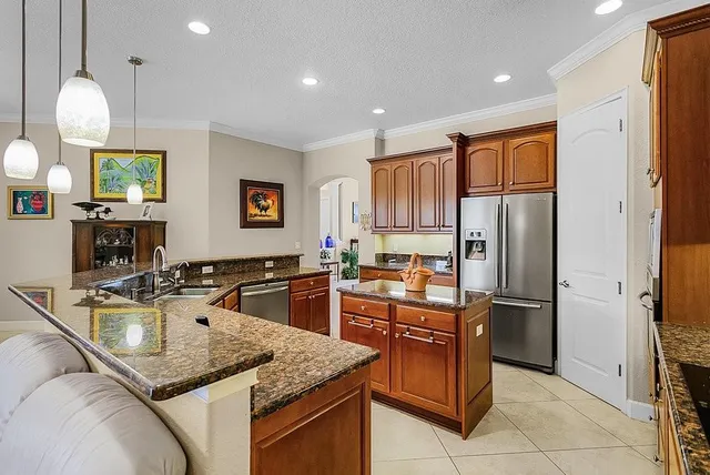 a kitchen with stainless steel appliances granite countertop a sink refrigerator and microwave