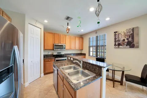 a kitchen with granite countertop a sink appliances and cabinets