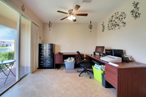 a view of a workspace with furniture and a window