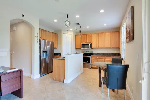 a kitchen with a refrigerator and a stove top oven
