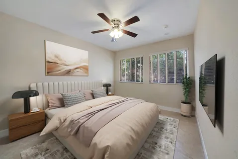 a bedroom with a large bed a chandelier and a window