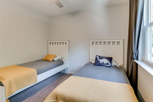 a bedroom with two beds and a large window