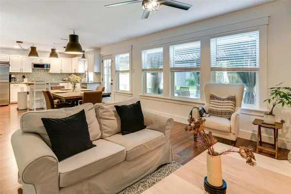 a living room with furniture fireplace and large windows