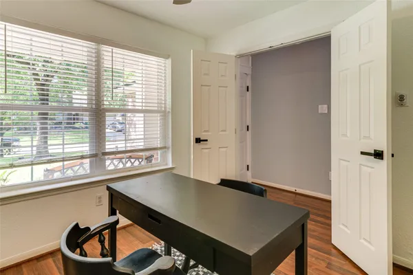 a view of an empty room with a window and wooden floor