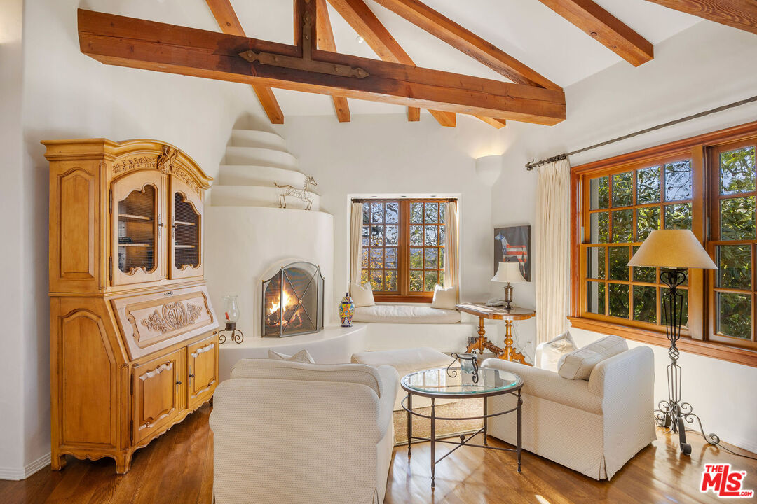 25127 Jim Bridger Road Hidden Hills, CA 91302 - Photo 11 of 50 a living room with fireplace furniture and a large window