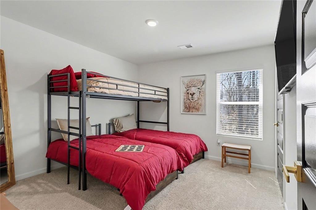 3732 Chevington Court Southeast Atlanta, GA 30354 - Photo 32 of 38 a bedroom with a bed a dresser and a flat screen tv