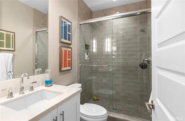 a bathroom with a sink mirror toilet and shower