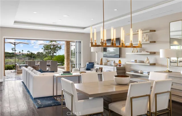 a room with stainless steel appliances kitchen island granite countertop a table chairs and a view of living room