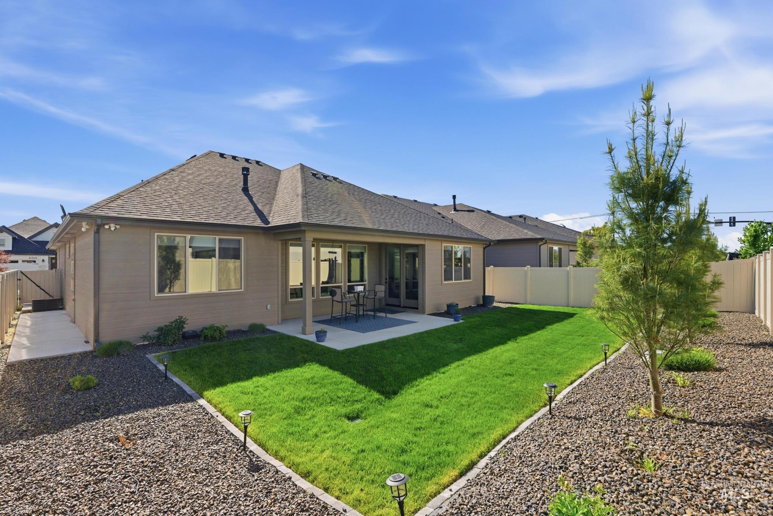 6347 South Utmost Lane Meridian, ID 83642 - Photo 4 of 37 Expansive backyard featuring a manicured lawn, gravel landscaping, and a young conifer tree