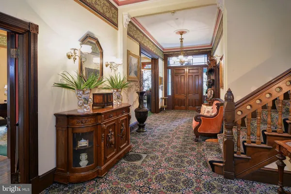 a view of a hallway with wooden furniture and windows