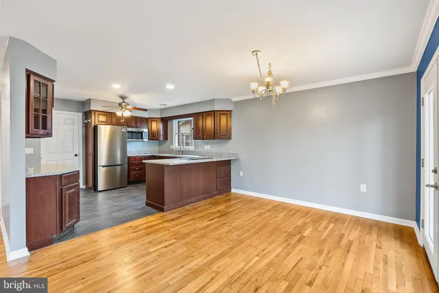a kitchen with stainless steel appliances kitchen island granite countertop a refrigerator and a stove top oven