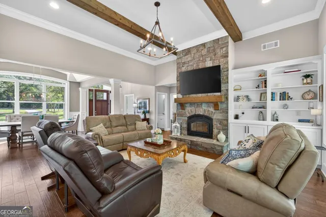 a dining room with furniture a chandelier and wooden floor
