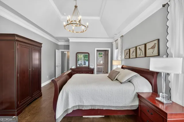 a view of a hallway with wooden floor and a bathroom