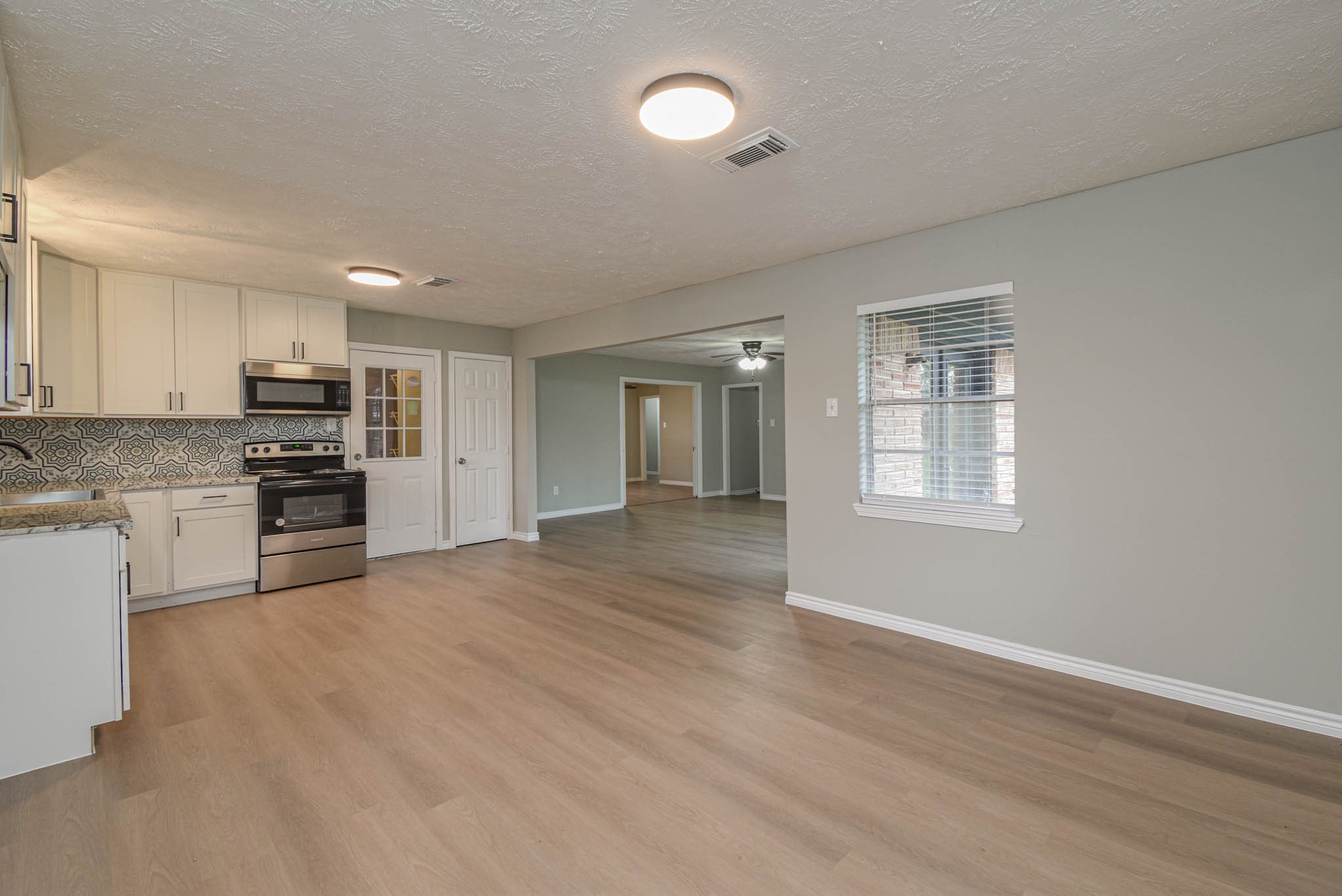 2834 Pansy Street Pasadena, TX 77503 - Photo 32 of 35 a open kitchen with kitchen island a stove a sink dishwasher and a refrigerator with wooden floor