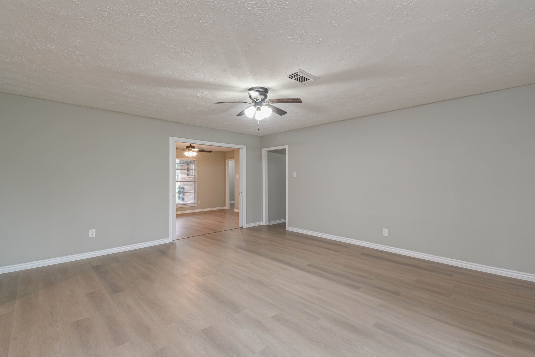 2834 Pansy Street Pasadena, TX 77503 - Photo 13 of 35 a view of an empty room with chandelier fan and wooden floor