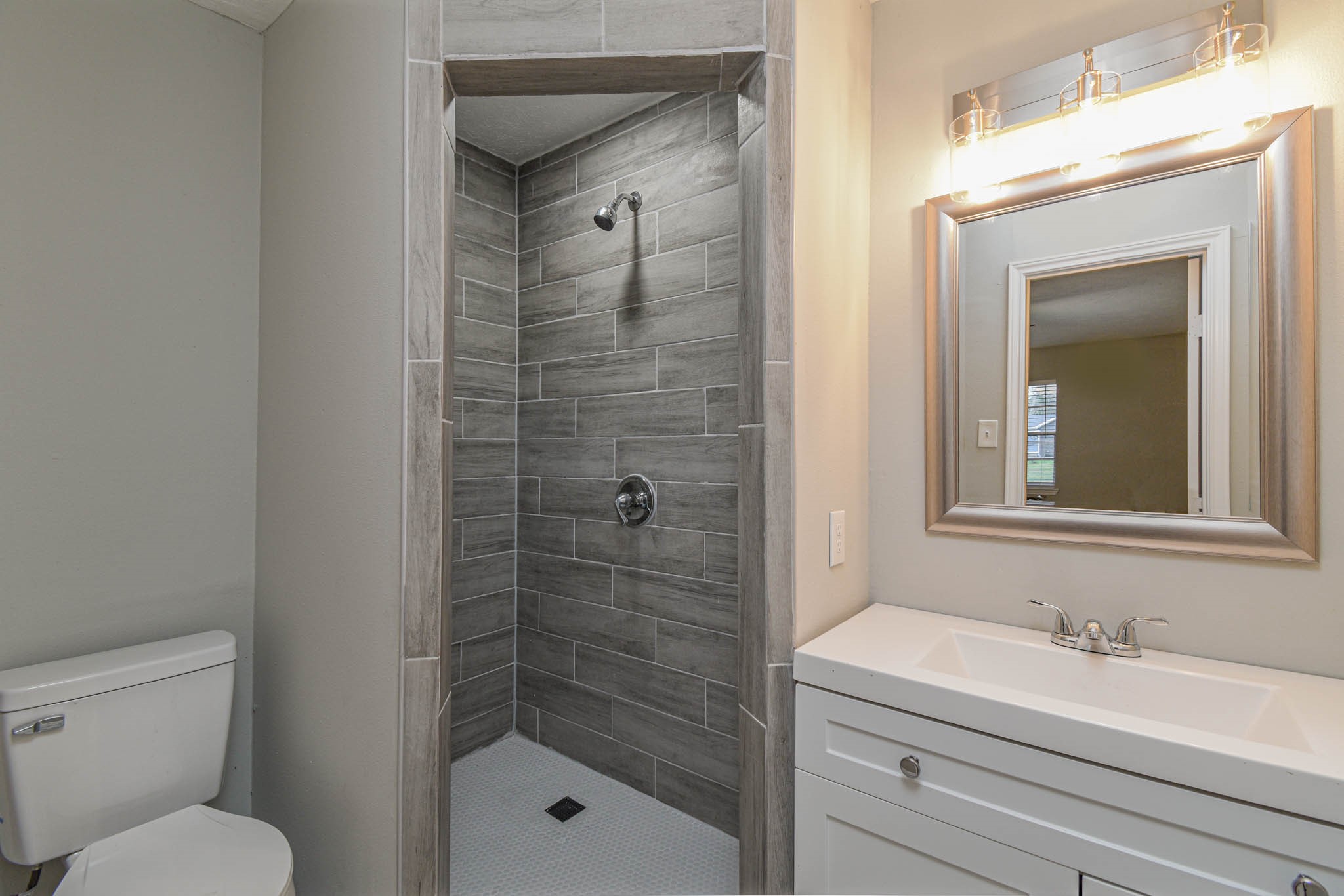2834 Pansy Street Pasadena, TX 77503 - Photo 19 of 35 a bathroom with a granite countertop toilet a sink and a mirror