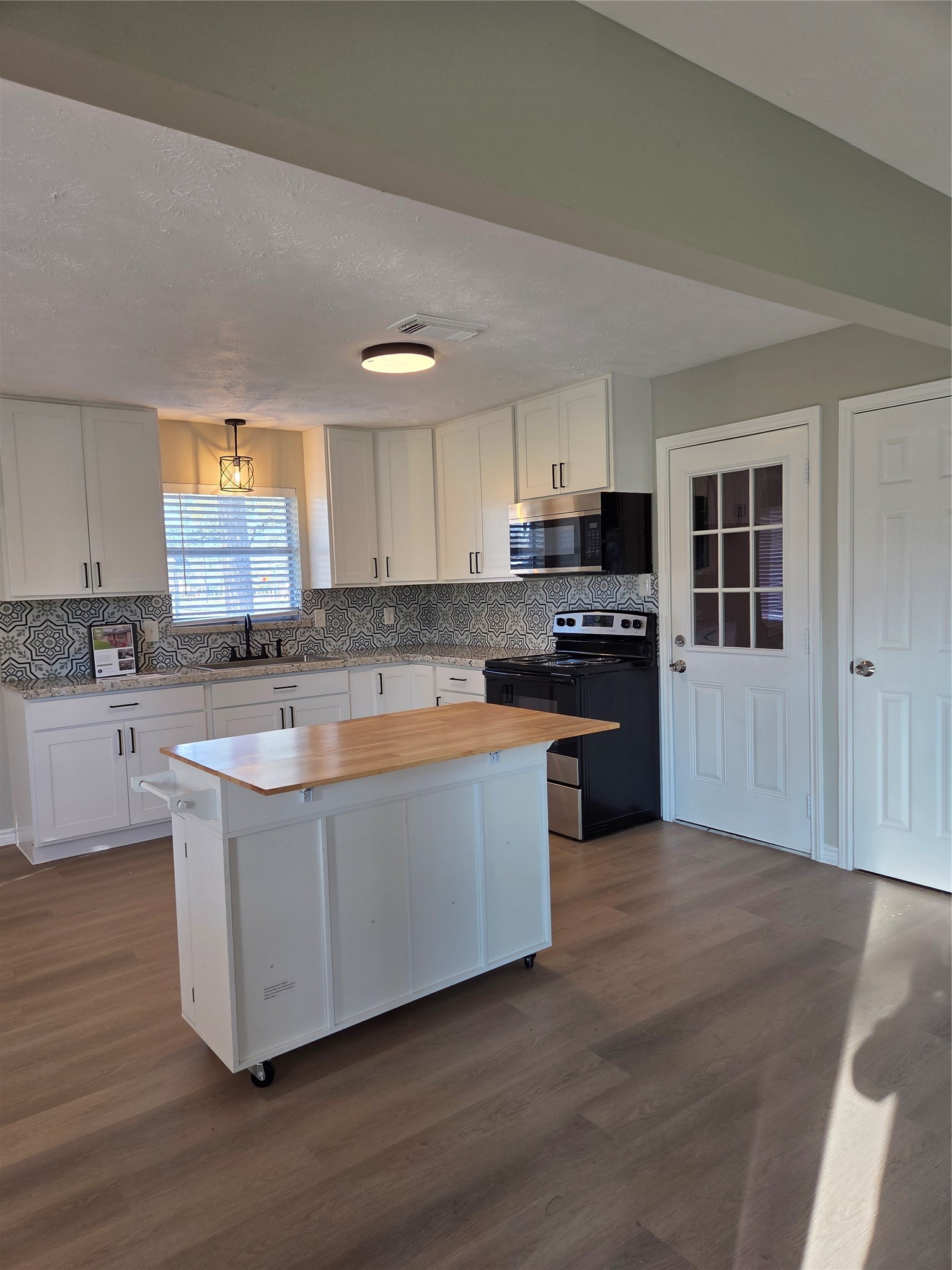 2834 Pansy Street Pasadena, TX 77503 - Photo 7 of 35 a large kitchen with a stove a sink and a microwave