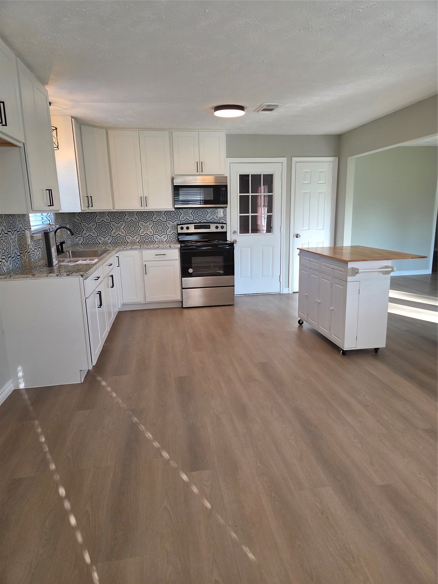2834 Pansy Street Pasadena, TX 77503 - Photo 9 of 35 a large kitchen with stainless steel appliances granite countertop a stove a sink and a refrigerator