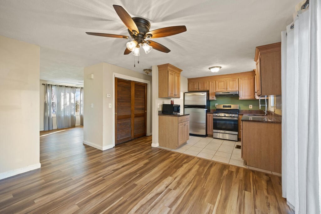 802 Lawrence Street, Unit D Lowell, MA 01852 - Photo 12 of 26 a kitchen with granite countertop stainless steel appliances and wooden floors