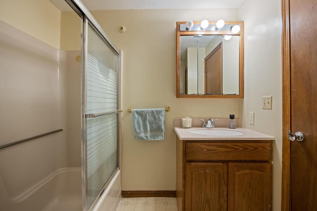 802 Lawrence Street, Unit D Lowell, MA 01852 - Photo 22 of 26 a bathroom with a sink a mirror and a shower