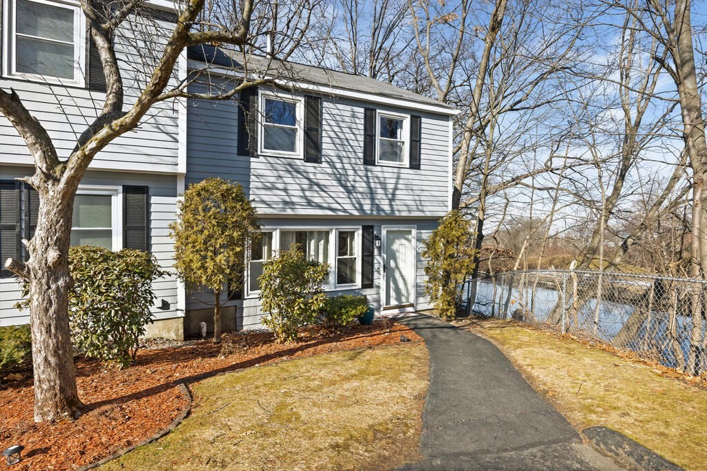 802 Lawrence Street, Unit D Lowell, MA 01852 - Photo 4 of 26 a front view of a house with a yard and potted plants