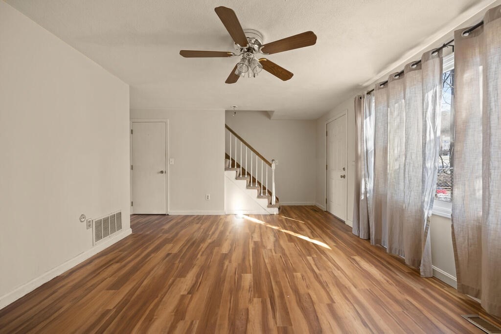 802 Lawrence Street, Unit D Lowell, MA 01852 - Photo 8 of 26 a view of empty room with wooden floor and fan