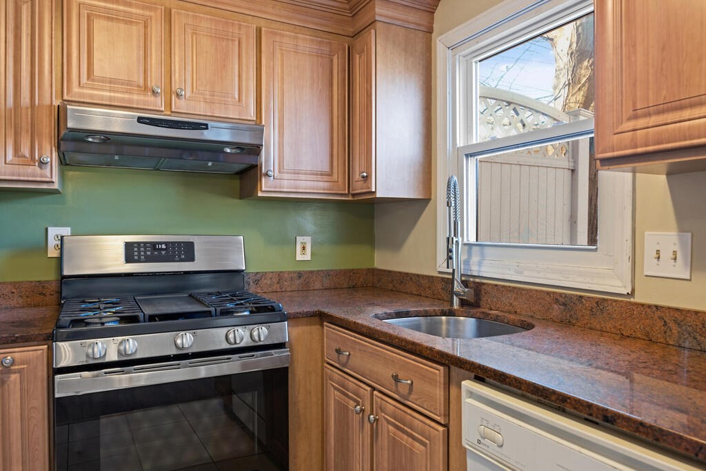 802 Lawrence Street, Unit D Lowell, MA 01852 - Photo 10 of 26 a kitchen with stainless steel appliances granite countertop a sink and a stove