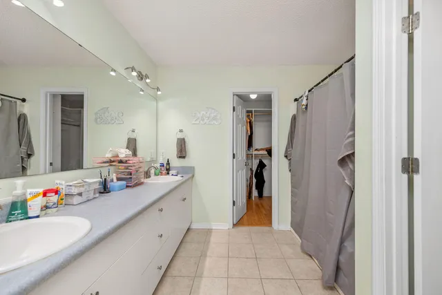 a bathroom with a double vanity sink mirror and shower