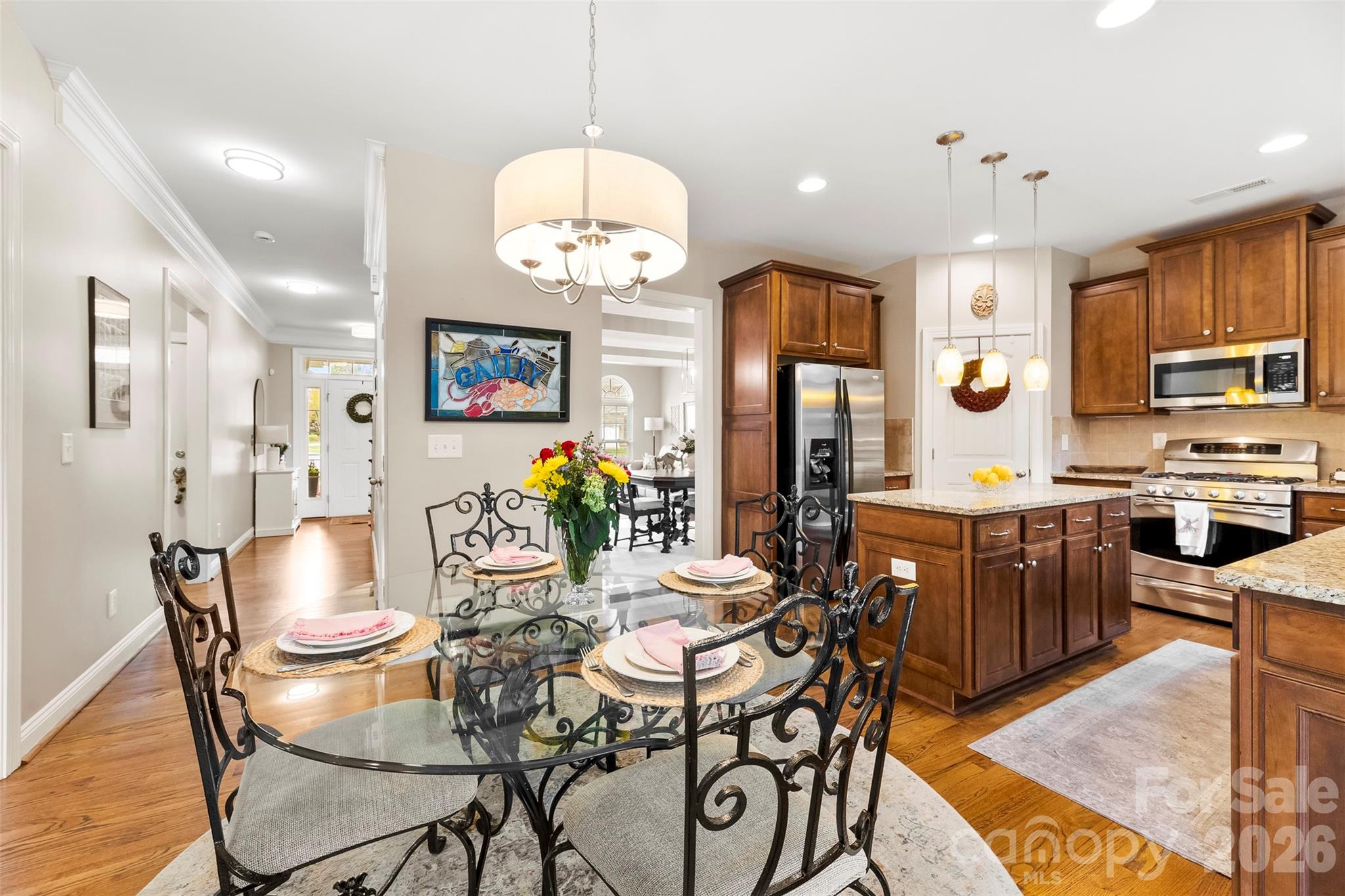 7574 Manakin Place Fort Mill, SC 29707 - Photo 12 of 40 a view of a dining room with furniture a chandelier and wooden floor