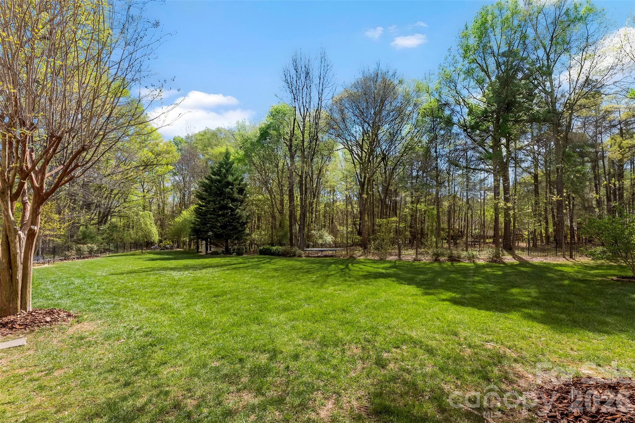 7574 Manakin Place Fort Mill, SC 29707 - Photo 30 of 40 a view of a grassy field with trees in the background