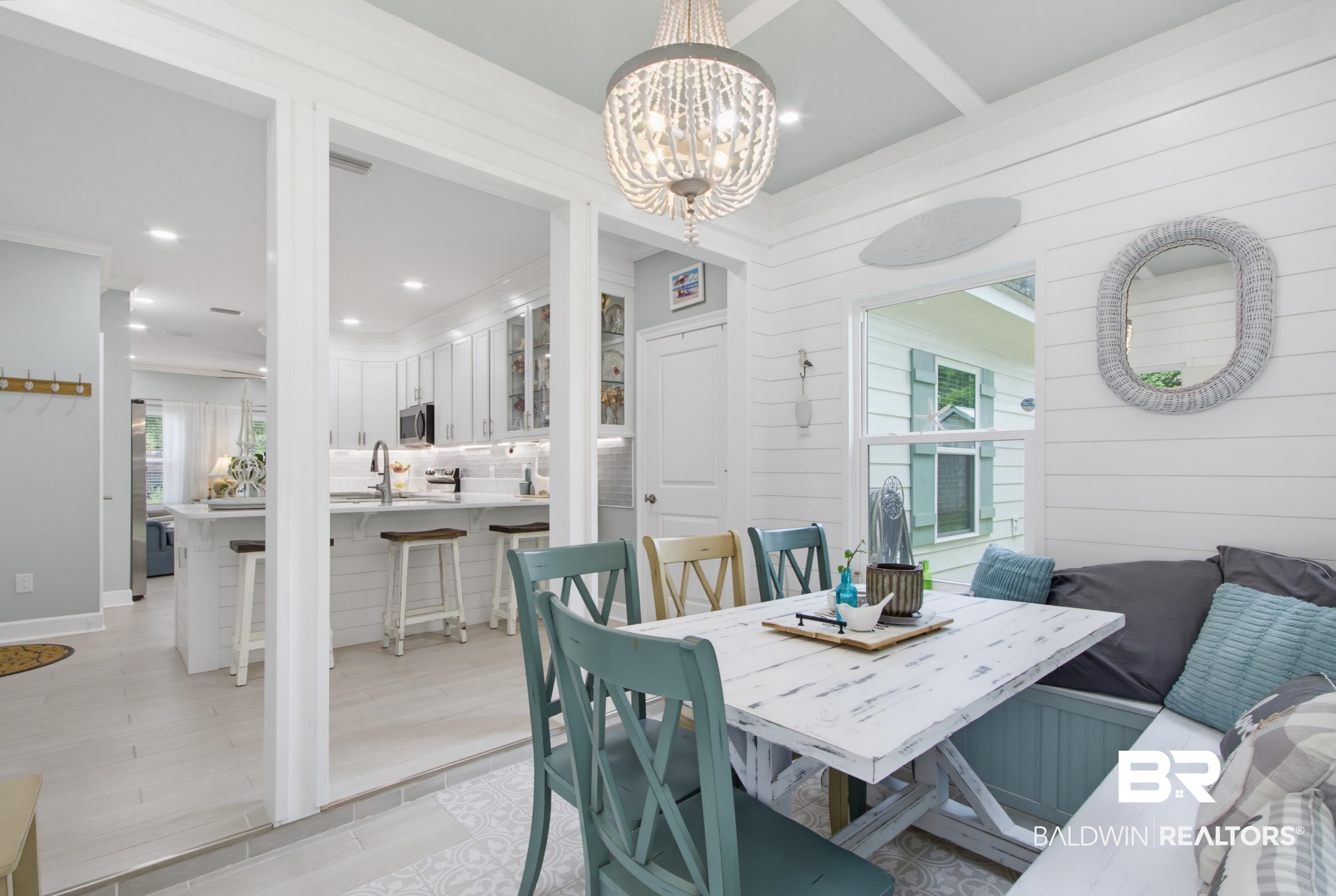 7472 Coopers Landing Road Foley, AL 36535 - Photo 15 of 40 Dining area featuring a built-in bench, shiplap wall finishes, and a beaded chandelier