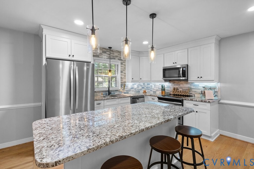 11440 Rochelle Road Chester, VA 23831 - Photo 6 of 31 a kitchen with stainless steel appliances granite countertop a refrigerator a stove a sink dishwasher a dining table and chairs with wooden floor