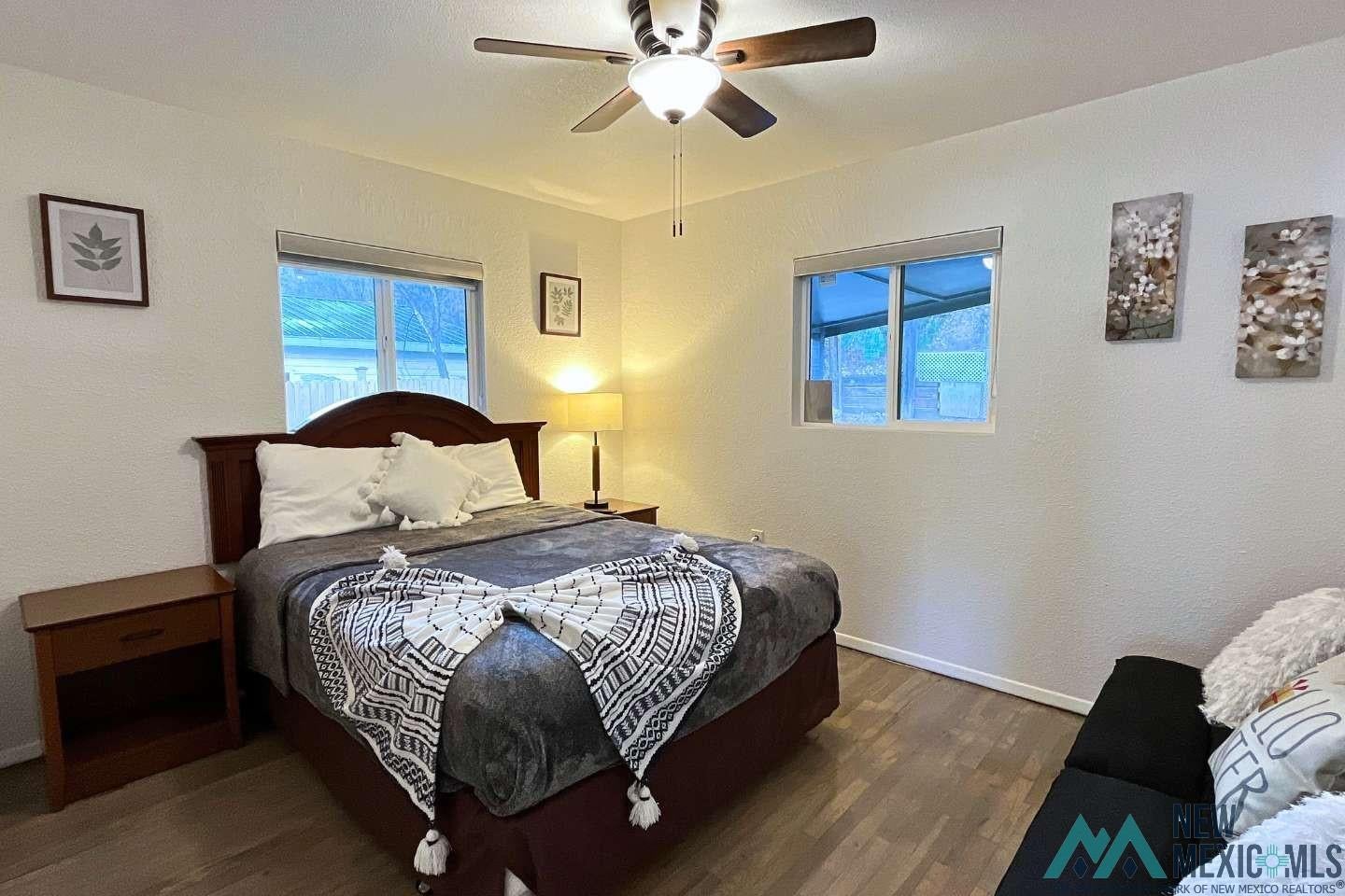241 Junction Road Ruidoso, NM 88345 - Photo 22 of 44 Bedroom featuring dark wood-style flooring, a textured wall, and a ceiling fan
