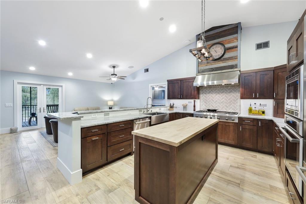 a large kitchen with kitchen island a sink counter top space and stainless steel appliances