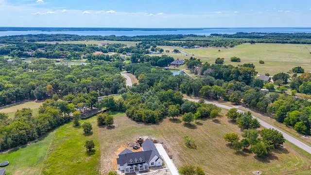 an aerial view of residential houses with outdoor space and lake view