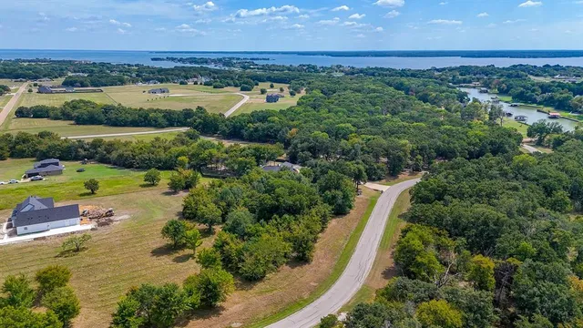 an aerial view of a houses with outdoor space and lake view