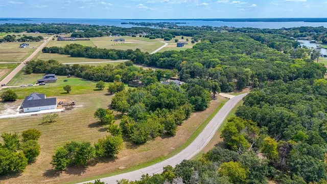 an aerial view of a house with a garden and lake view