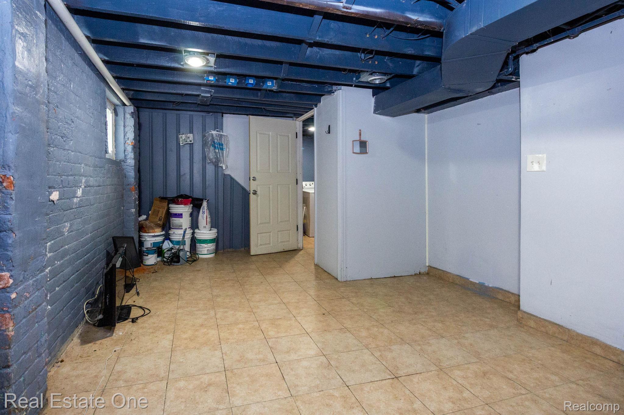 5485 Springwells Street Detroit, MI 48210 - Photo 39 of 47 Spacious basement featuring light-toned tile flooring and painted brick walls