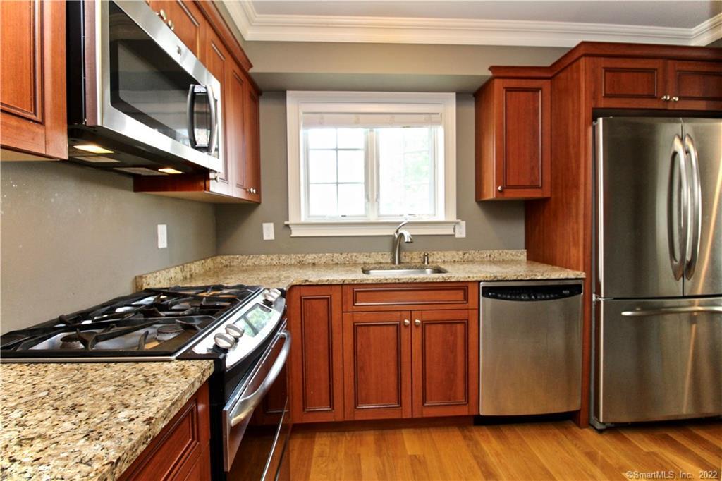 109 Forest Street, Unit 5 Stamford, CT 06901 - Photo 2 of 21 a kitchen with stainless steel appliances granite countertop a stove a sink dishwasher and a refrigerator