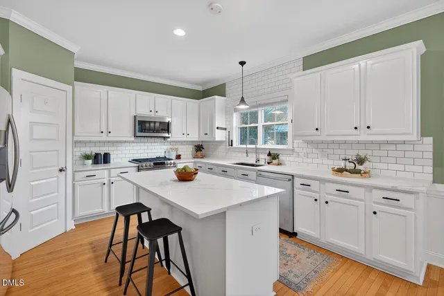 a kitchen with stainless steel appliances a sink a stove a microwave and cabinets