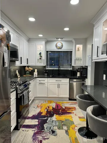 a kitchen with stainless steel appliances kitchen island granite countertop a sink and cabinets